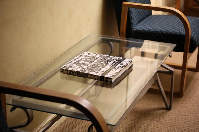 Sklenený stolík, knižka položená na sklenenom stolíku